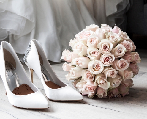 Zapatos blanco de boda y ramo de rosas blancass